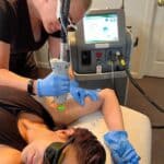 Student gaining hands-on experience with a cosmetic laser.